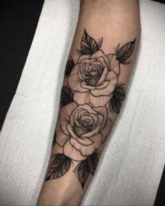 Фото татуировки с изображением двух роз на предплечье, выполненной в стиле blackwork. Четкие контуры и плотное заполнение черным цветом создают элегантный и стильный образ.
