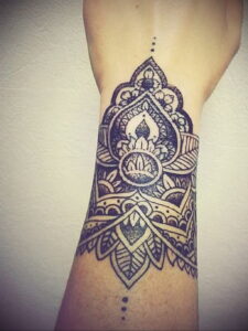 Фото тату: сложная татуировка мандалы на запястье, выполненная в технике dotwork, с использованием множества точек для создания узоров.