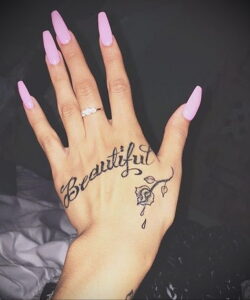 Фото тату: стильная татуировка на руке с надписью 'Beautiful' и изображением розы. Черно-белый рисунок татуировки, выполненный на женской руке.