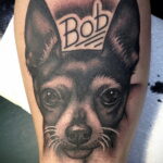 Фото татуировки чихуахуа с надписью 'Bob' на голове собаки. Рисунок выполнен в черно-белой гамме с высокой детализацией.