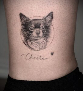 Фото татуировки чихуахуа в круге с надписью 'Chester' и маленьким сердечком. Детализированный портрет собаки в черно-белой гамме.