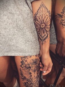 Фото декоративной татуировки в стиле Mandala на бедрах. Сложный узор с цветочными элементами и геометрическими фигурами.