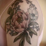 Фото тату на плече: реалистичное изображение пионов и анемон, выполненное в мягких пастельных тонах. Красивая и женственная татуировка.