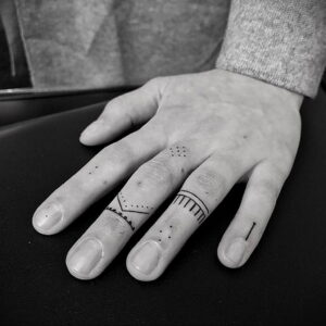 Фото татуировок на пальцах: минималистичные геометрические узоры и точки. Оригинальный эскиз тату для креативных личностей.