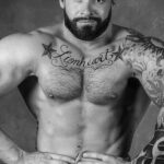 Фото тату: татуировка на груди мужчины с надписью "Lionheart" в окружении звезд. Черно-белый рисунок в стиле олдскул.