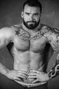Фото тату: татуировка на груди мужчины с надписью "Lionheart" в окружении звезд. Черно-белый рисунок в стиле олдскул.