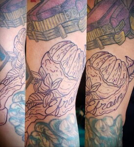 Фото эскиза татуировки апельсина, выполненного в технике line work, с добавлением небольших цветов и надписи 'Efrain'.