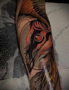 Фото тату на руке: крупный портрет совы с горящими глазами, выполненный в стиле neo traditional с использованием ярких цветов и детализированной прорисовки.
