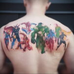 Фото тату с изображением команды супергероев Marvel и DC на спине. Акварельный стиль, яркие цвета, динамичная композиция.
