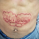 Фото тату на животе: надпись "CALIBORN" в стиле граффити, выполненная красными чернилами. Оригинальный рисунок татуировки, привлекающий внимание.