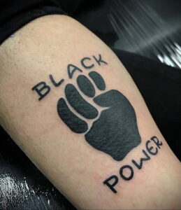 Фото тату на ноге: стилизованное изображение черной лапы с надписями 'BLACK' и 'POWER', символизирующее силу и гордость.