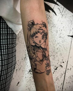 Черно-белая татуировка на руке, изображающая Sailor Moon в характерной позе, с детальной проработкой и использованием традиционных элементов аниме.