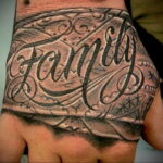 Фото тату надписи 'Family' на руке, выполненной в стиле традишнл с использованием черных линий и ярких акцентов. Идеально для тех, кто ценит семейные ценности.