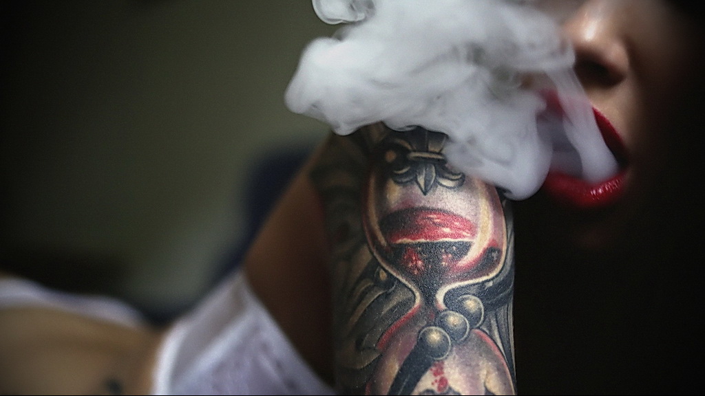 Курящая девушка в татуировках