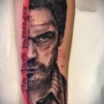 Фото тату на руке с изображением Декстера Моргана. Портрет с надписью 'The dark passenger' и брызгами крови.