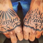 Фото тату на ладонях с надписями 'Punya' и 'Paap' на хинди, окруженными лучами света и пламенем.