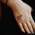 Фотография минималистичной татуировки на руке с надписью 'i have got to be'. Черная надпись выполнена простым шрифтом.