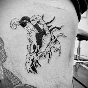 Фото абстрактной татуировки скорпиона, выполненной в стиле blackwork. Черно-белый рисунок с геометрическими формами и линиями, создающий уникальный и запоминающийся образ.