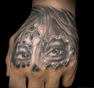 Фото тату глаз и роз на руке. Детализированный рисунок с проработкой глаз и лепестков, выполненный в черно-серых тонах.