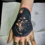 Фото татуировки Скорпиона из Mortal Kombat на руке, выполненной в стиле blackwork. Четкий и контрастный рисунок.