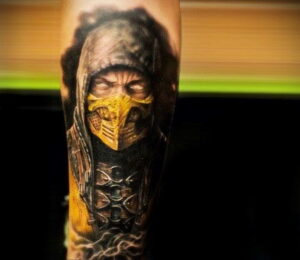 Фото татуировки Скорпиона из Mortal Kombat на предплечье. Детализированный рисунок с использованием ярких цветов и светотени.