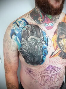 Фото яркой и детализированной татуировки персонажа Sub-Zero из Mortal Kombat на груди и плече мужчины. Изображение выполнено в насыщенных синих и белых тонах.
