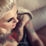 Фото тату на ключице девушки, демонстрирующее красочный цветочный рисунок в стиле традиционной татуировки с акцентом на детализацию.