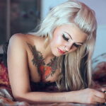 Фото тату на ключице девушки, демонстрирующее красочный цветочный рисунок в стиле традиционной татуировки с акцентом на детализацию.