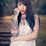 Фото тату на руке девушки в стиле Old School: корабль, роза, сердце и череп, яркие цвета и четкие контуры.