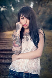Фото тату на руке девушки в стиле Old School: корабль, роза, сердце и череп, яркие цвета и четкие контуры.