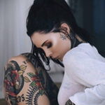 Фото девушки с множеством татуировок в стиле Old School на теле, включая бабочек, цветы и узоры. Яркий и привлекательный дизайн татуировок.