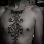 Фото тату: Мужчина с большой татуировкой в стиле dotwork на груди. Черно-белый рисунок с геометрическими узорами.