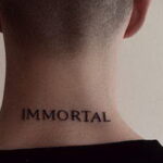 Фото минималистичной татуировки надписи 'IMMORTAL' на задней части шеи мужчины. Простой, но выразительный дизайн в черном цвете.