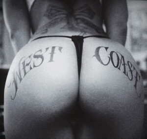 Фото татуировки с надписью 'WEST COAST' на ягодицах. Минималистичный рисунок татуировки, выполненный черными чернилами.