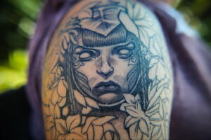 Фото тату с изображением портрета женщины в стиле blackwork. Рисунок выполнен только черными чернилами с использованием тонких линий и точечной техники.