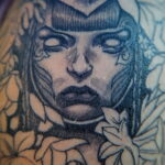 Фото тату с изображением портрета женщины в стиле blackwork. Рисунок выполнен только черными чернилами с использованием тонких линий и точечной техники.