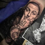 Фото тату на руке с реалистичным портретом Mac Miller, показывающим часы на руке. Детализированный рисунок татуировки.