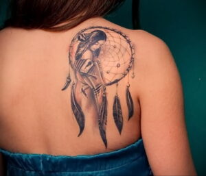 Фото тату ловца снов с изображением девушки на спине. Черно-белый рисунок в стиле реализм.