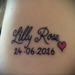 Фото тату с именем 'Lilly Rose' и датой рождения '24.06.2016', украшенной маленьким красным сердечком.