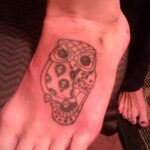 Фото татуировки совы, выполненной в стиле сахарной черепушки (sugar skull) на стопе. Яркий и оригинальный дизайн.