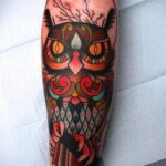 Яркая и красочная татуировка совы в стиле олд скул, с использованием толстых черных контуров, насыщенных цветов и традиционных элементов. Динамичный и привлекательный дизайн.