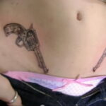Фото тату двух револьверов на животе. Черно-серый рисунок татуировки, выполненный в минималистичном стиле. Подходит для тех, кто хочет выразить свою индивидуальность.