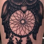 Фото тату совы с ловцом снов, выполненное в стиле black and grey на руке. Детализированный рисунок с использованием теней и полутонов.