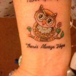 Фото тату совы на запястье с надписью 'Never Give Up' и 'There's Always Hope'. Маленькая сова сидит на ветке с цветком.