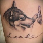 Фото тату хаски с надписью "Leah" и сердечком. Черно-белый рисунок с реалистичным изображением собаки и нежной надписью.