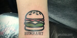 Фото тату: минималистичный бургер с надписью 'Hungry', выполненный на руке в простом стиле. Небольшая и лаконичная татуировка.