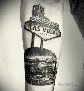 Фото тату реалистичного бургера на фоне вывески 'Welcome to Las Vegas'. Черно-белый рисунок, детализированный и атмосферный.