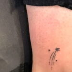 Фото тату: маленькая падающая звезда, выполненная тонкими линиями на запястье. Идеально для тех, кто ищет нежную и минималистичную татуировку.