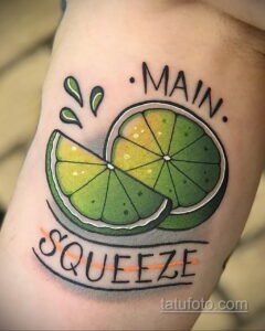 Фото тату на руке: половинка лайма с надписью 'Main Squeeze'. Яркие цвета, четкие контуры, традиционный стиль.