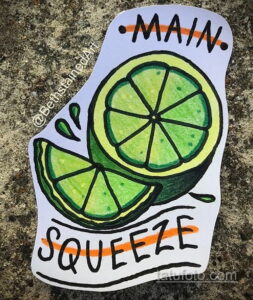 Фото татуировки с изображением двух долек лайма и надписей "MAIN" и "SQUEEZE". Яркий, сочный дизайн, стиль олдскул.